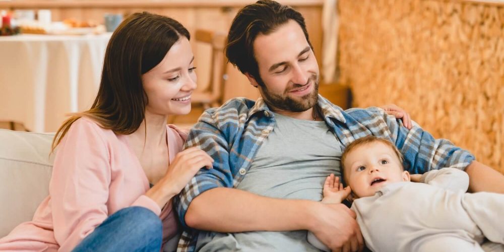 Happy young couple enjoying time with their baby at home.